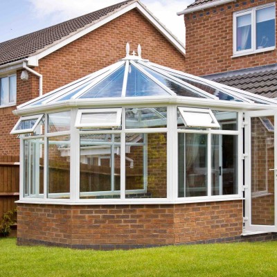 Conservatory with glass roof against a red brick house